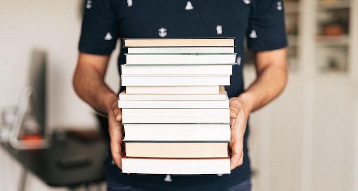 holding stack of books.jpg.optimal