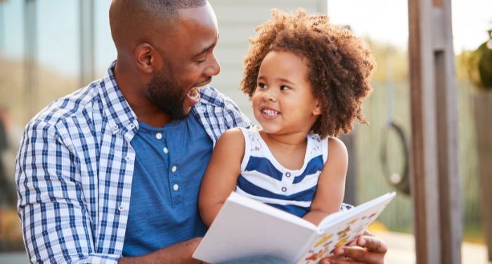 child parent reading laughing.jpg.optimal